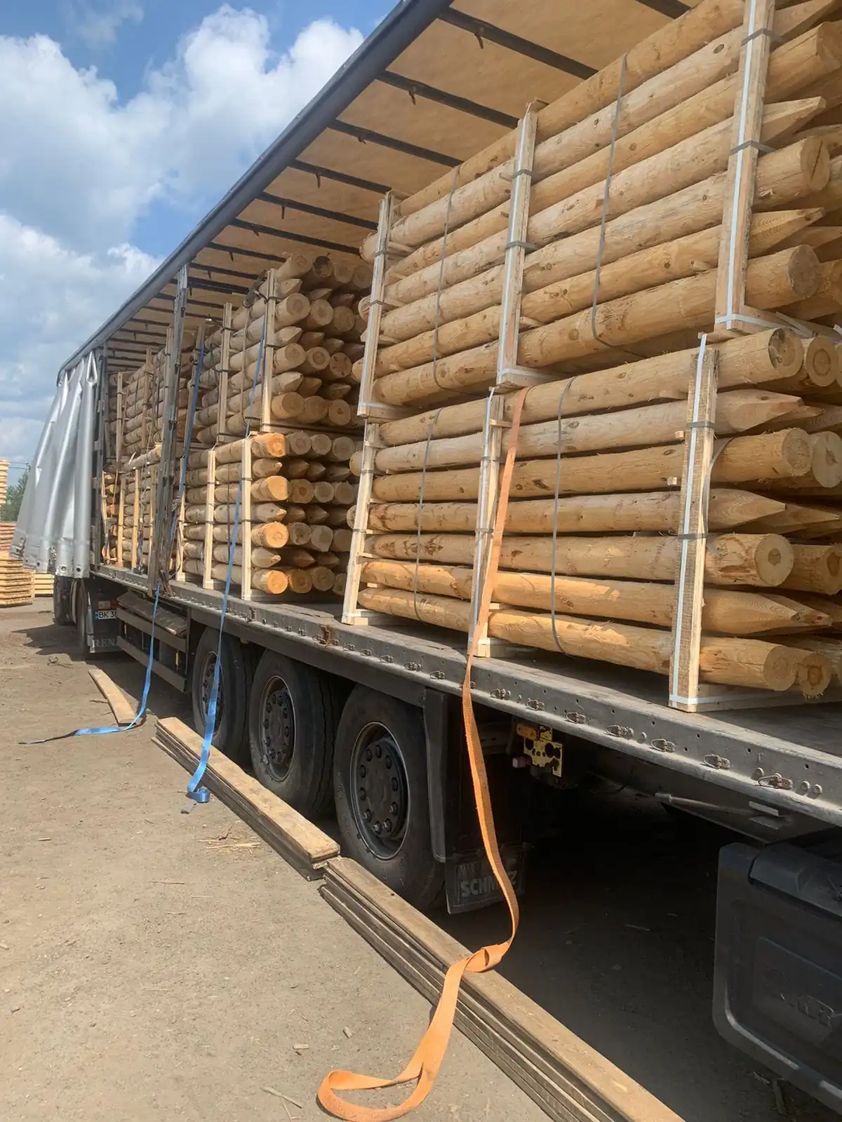 Rondins de bois bien arrimés sur un camion, destinés à la livraison depuis l'entrepôt de PéSim.