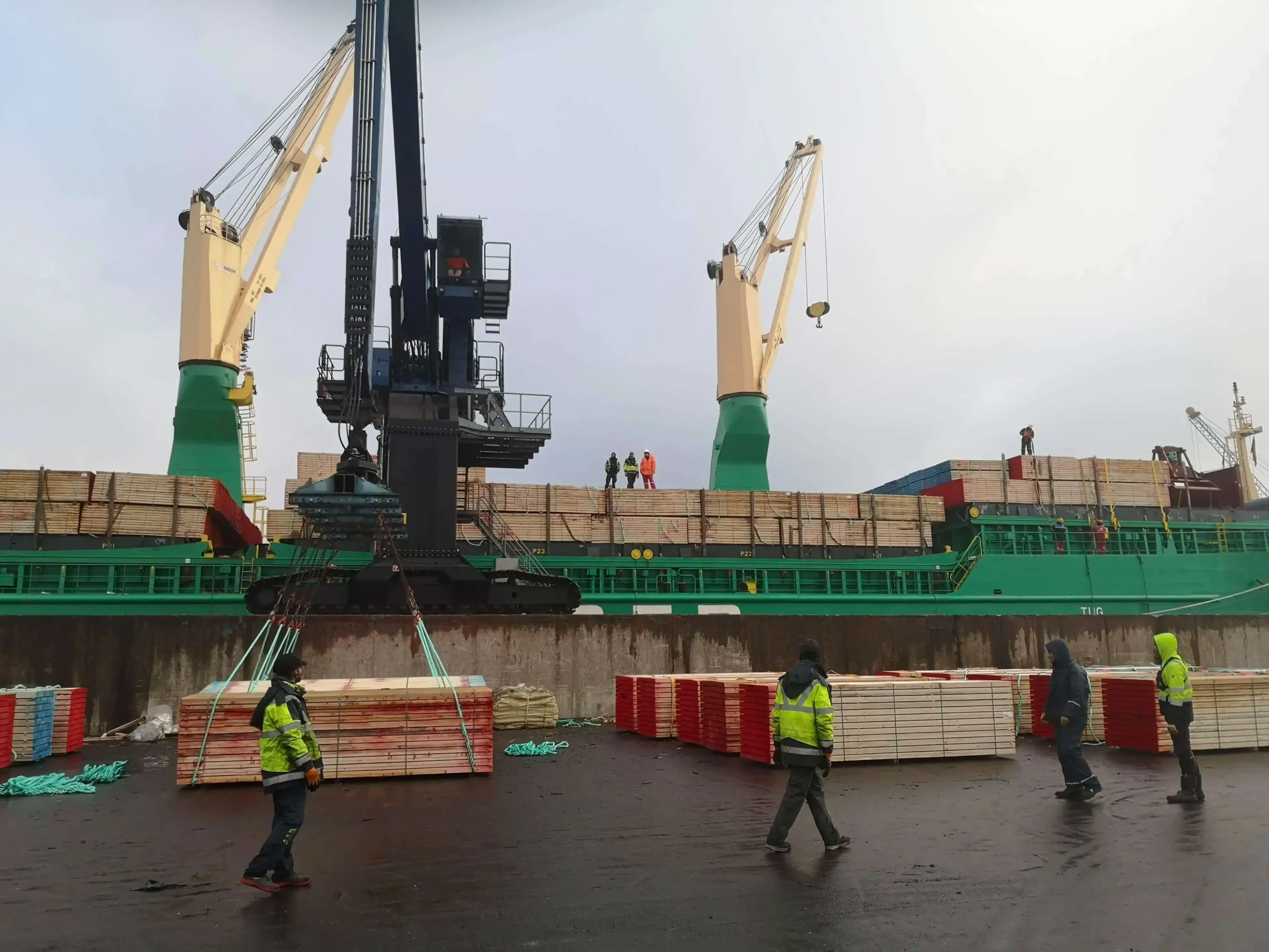 Importation de bois par PéSim avec déchargement depuis un navire avec grue au port.